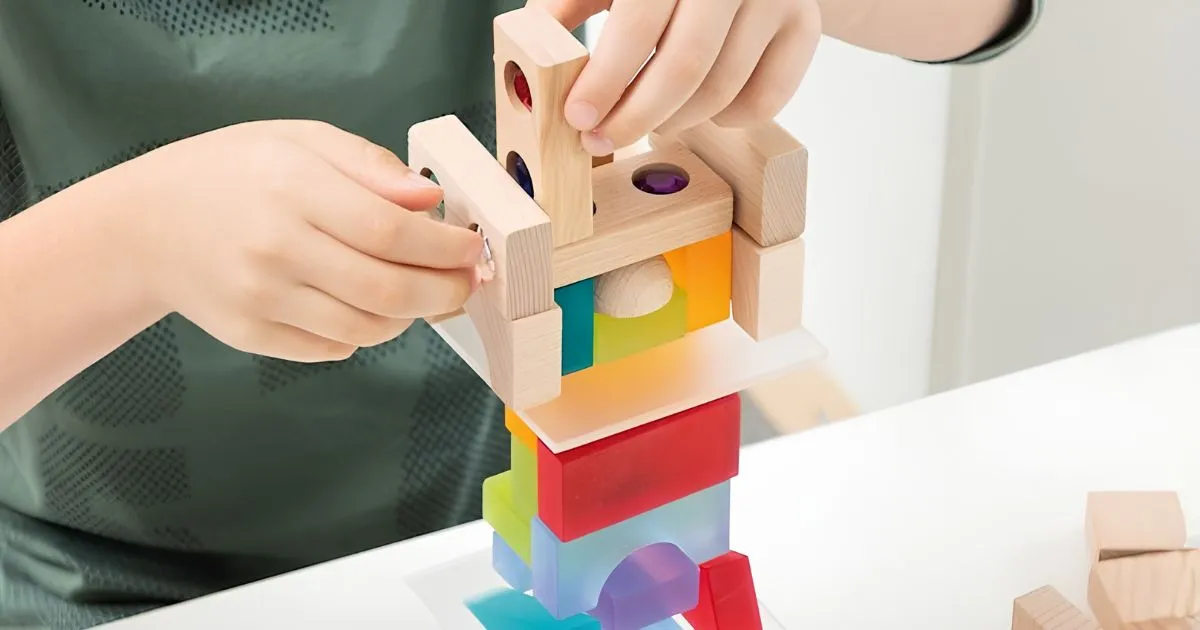 デュシマ社のジュエル積木とLuxyブロックを積み上げる子どもの手元